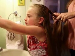 MS Mother braiding her daughter hair / St. Simon's Island, Georgia, United States Stock Footage