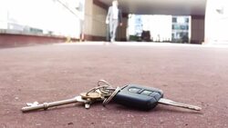 Businessman walking towards then picking up his keys Stock Footage