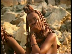 CU Pan left, Mother and daughter of Himba tribe sitting, Namibia Stock Footage