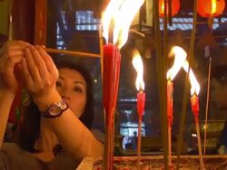 CU Shot of Woman worshiper lights incense at Man Mo Temple / Hong Kong, Special Administrative Region, China  Stock Footage