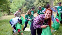 Portrait of smiling environmentalist volunteer picking up trash Stock Footage