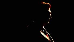 A ray of light casts shadows on a businessman's face. Stock Footage