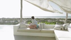 Woman looking at ocean view from luxury patio Stock Footage
