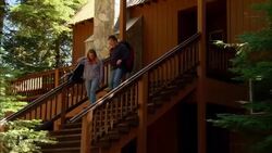 MS, PAN, USA, California, Shaver Lake, Couple with backpacks descending bungalow steps Stock Footage