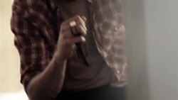 Young man sulks on motel bed as young woman paces back and forth behind him Stock Footage