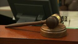 A gavel rests on a table in a courtroom. Stock Footage