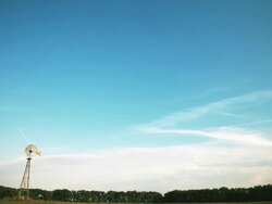 Timelapse of clouds over a windmill, beautiful blue sky Stock Footage