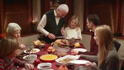 Grandfather serving turkey slices onto granddaughters plate Stock Footage
