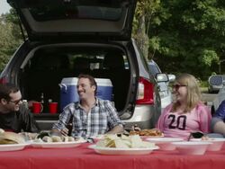 MS Tailgaters toasting bottles behind table of food / Valhalla, New York, United States Stock Footage