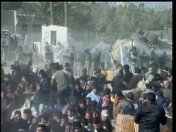 Egyptian border guards with riot shields form human chains, trying to reseal Egypt's breached border with Gaza. Still, Palestinians managed to sneak through. Some threw stones at the Egyptian guards News Clip