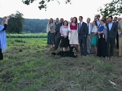 WS Family and friends standing in field while woman takes digital photo of group at sunset/Washington, USA Stock Footage