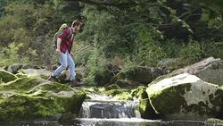 Young man jumping over the river Stock Footage
