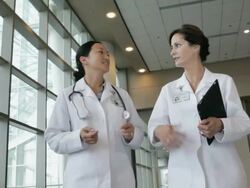 MS POV Two female physicians walking along hospital corridor and talking / Seattle, Washington, USA Stock Footage