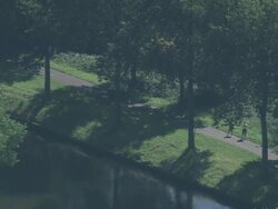 MS AERIAL TS PAN View of bicyclers moving by canal in city / Flanders, Belgium Stock Footage