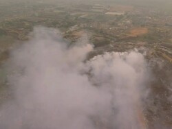 WS AERIAL DS View of rubbish dumping ground with smoke around / Lagos, Nigeria Stock Footage