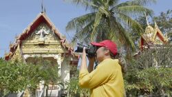 Woman photographing Wat Na Phra Lan temple Stock Footage