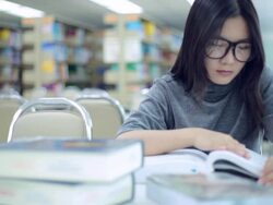 Woman read a book in library Stock Footage