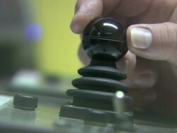 Medium Close Up hand-held pan-left pan-right tilt-down zoom-in - A hand manipulates a control stick. / Scotland Stock Footage