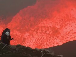 Gas blows past climber standing above lava lake, Marum Volcano, Ambrym Island, Vanuatu Stock Footage