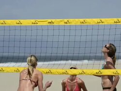 CU of female beach volleyball players spiking and blocking at the net. Stock Footage