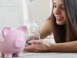 MS Woman placing coins in piggy bank / Jersey City, New Jersey, United States Stock Footage