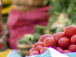 Plum tomatoes in basket, focus changes to long beans and other vegetables in b/g, La Cancha Market, Cochabamba, Bolivia Stock Footage