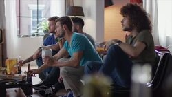 Guys sitting on couch watching tv and cheering Stock Footage