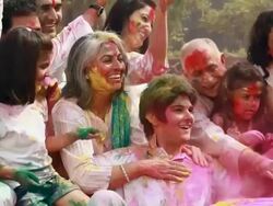 Family celebrating holi festival in the lawn  Stock Footage