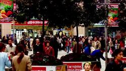 Chinese citizens walk through a crowded plaza. Stock Footage