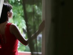 MS Young woman looking out through  window of house / Singapore Stock Footage