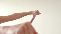 A mature woman uses a stretch band in her home gym. Stock Footage