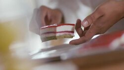 Pastry chef's hands  lift cake from tray and place on dessert dish Stock Footage
