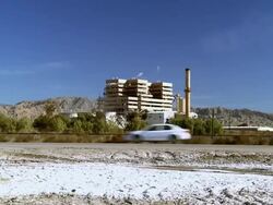 WS ZI Cars moving across desert road in front of power plant / Thermal, California, USA Stock Footage