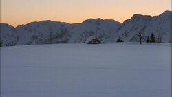 The roof of a cabin sticks up out of a snow-covered plain. Stock Footage