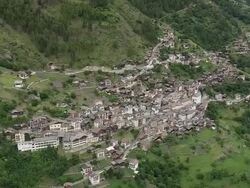 MS AERIAL ZO Shot of houses on mountain hill and farm fields, Iserables / Valais, Switzerland Stock Footage
