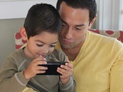 MS Father and Young Son Playing Video Game on Smart Phone / Eastville, Virginia, USA Stock Footage