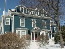 MS Shot of waving flag on house with pile of snow and car passing on street / Boston, Massachusetts, United States Stock Footage