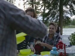 Friends setting picnic table at campsite Stock Footage