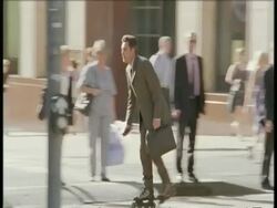 MS business man on rollerblades weaves in and out of traffic and pedestrians Stock Footage