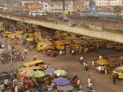 WS Market with cross bridge and yellow cabs under it / Lagos, Nigeria Stock Footage