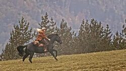 SLO MO TS Cowgirl riding her galloping horse uphill Stock Footage