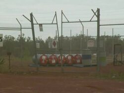 Fuel drums behind security fence, Australia Stock Footage