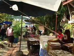 MS POV SLO MO Travelling of street market with parasols people walking by and products and stands along each side of street / Luang Prabang, Laos Stock Footage