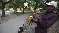 Old man plays saxophone in New York City park Stock Footage