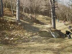 HD: Downhill Bikers Jumping Over Dirt Jump Stock Footage