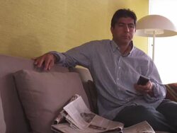 MS Man on couch, checking newspaper, using TV remote / Portland, Oregon, United States Stock Footage