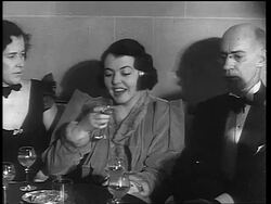 B/W 1933 woman sitting between woman + man drinking from glass / end of Prohibition Stock Footage