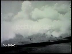1943: LANDING AT NADZAB, LAE CAMPAIGN: VS U.S. Army 503rd Infantry Regiment paratroopers preparing line, Douglas C-47 Skytrains flying over Owen Stanley Range w/ smoke screen, line of paratroopers jumping out of plane, parachutes opening. WWII Instructional Video