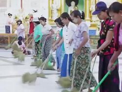 MS TS Shot of Women sweeping street in front of temples (seen from side) / Yangon, Yangon Division, Myanmar  Stock Footage