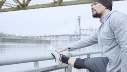 Ethnic adult male stretching before exercise in the city Stock Footage